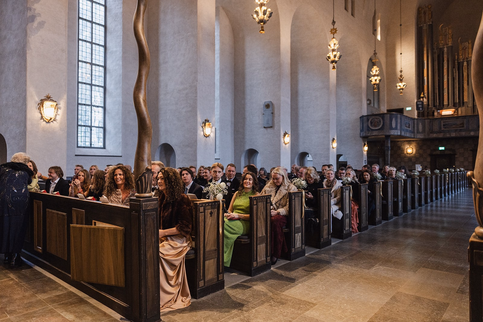 Wedding guests seated inside Högalidskyrkan before the ceremony.
