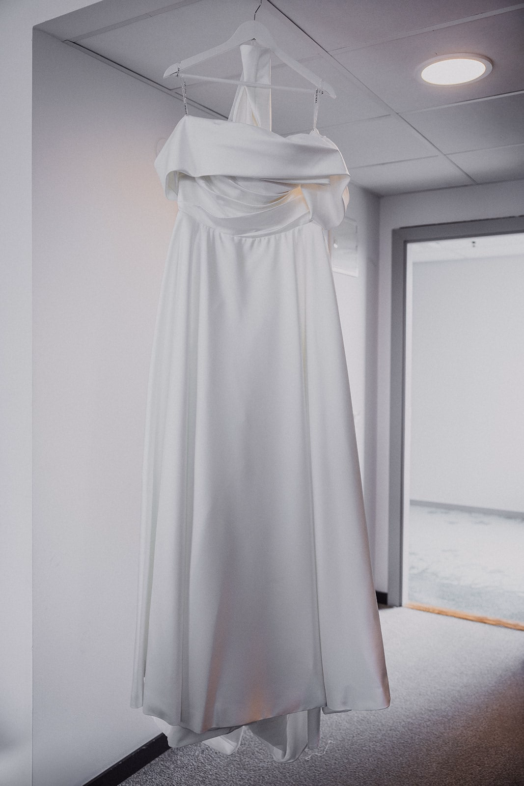 The wedding dress hanging by a window before the ceremony.
