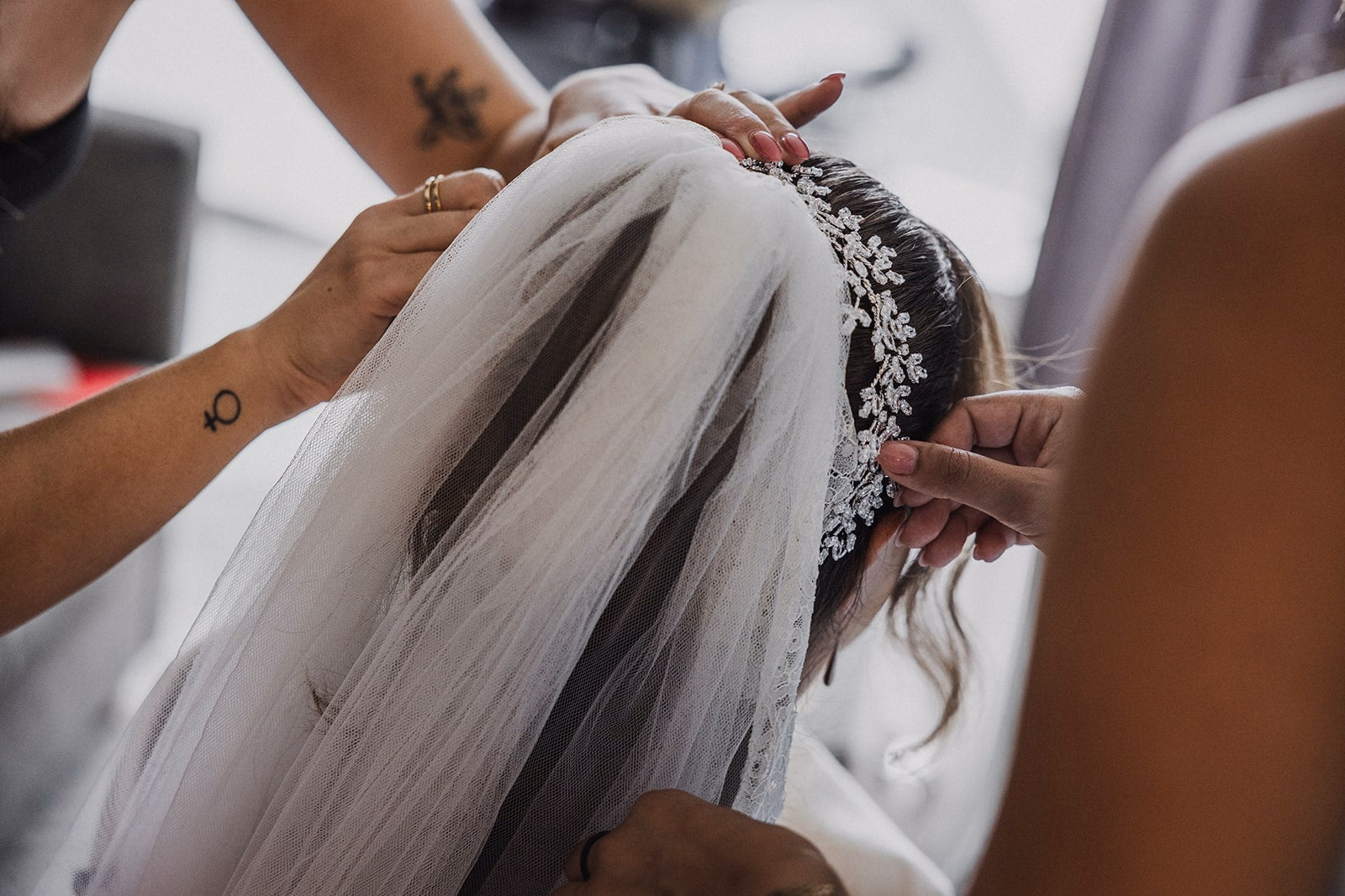 The bride’s veil being pinned into place.