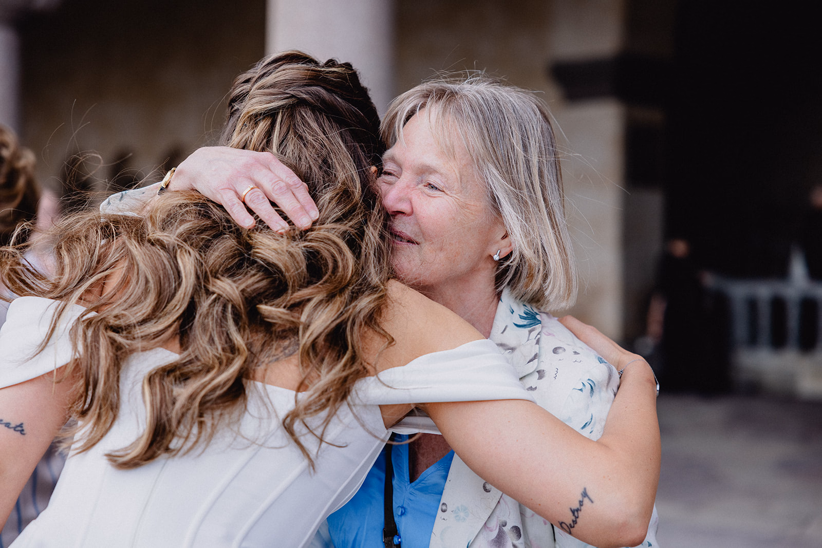 The bride embracing a guest in the courtyard at Stockholm City Hall.