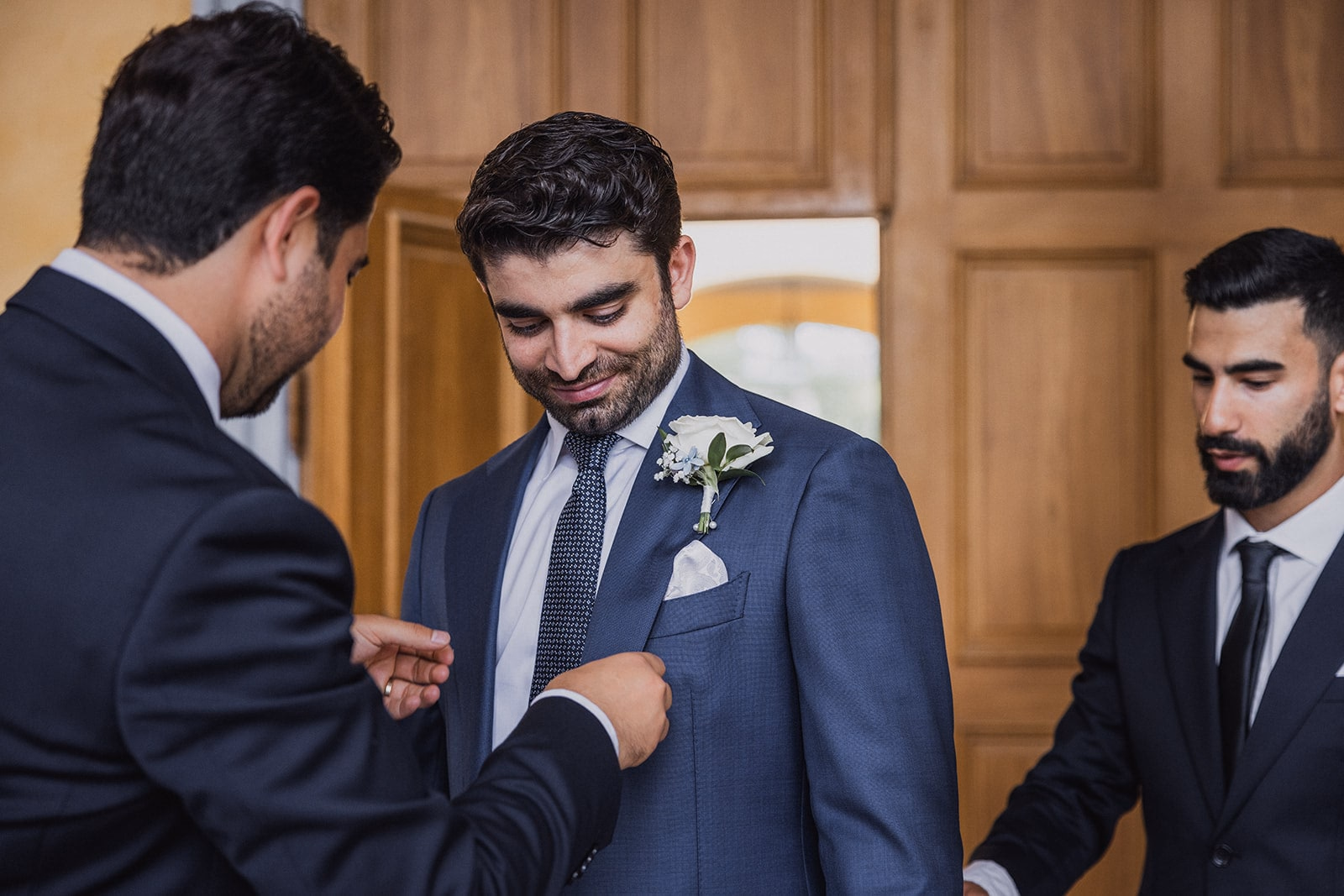 The groom’s boutonniere being adjusted before the ceremony.
