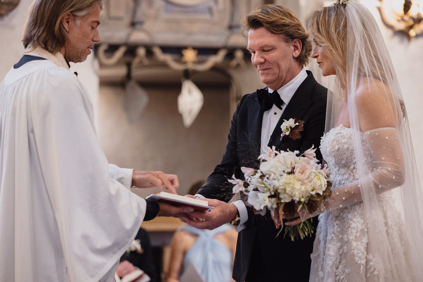 The couple standing with the officiant during their church ceremony.