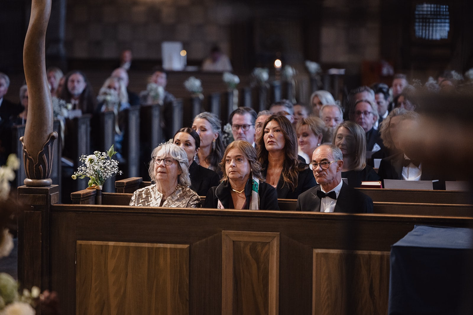 Wedding guests watching the ceremony from the front pews.