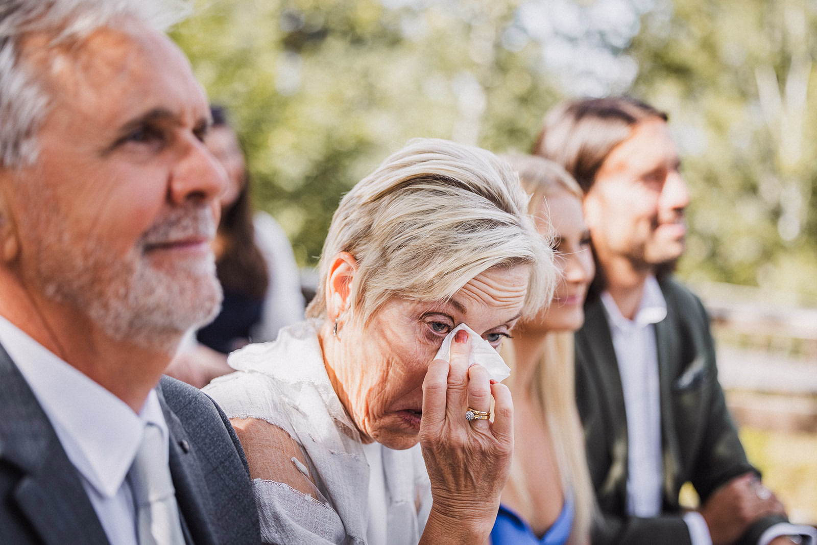A wedding guest wiping away tears during the ceremony.