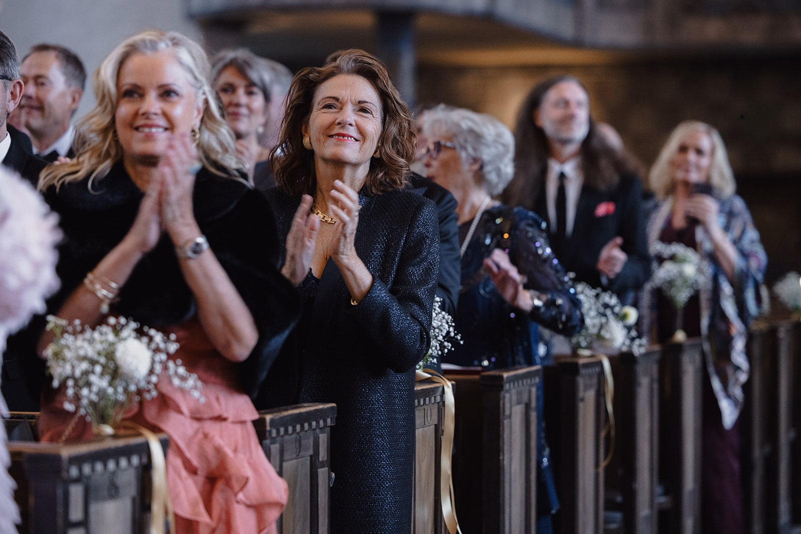 Wedding guests applauding from the pews at Högalidskyrkan.