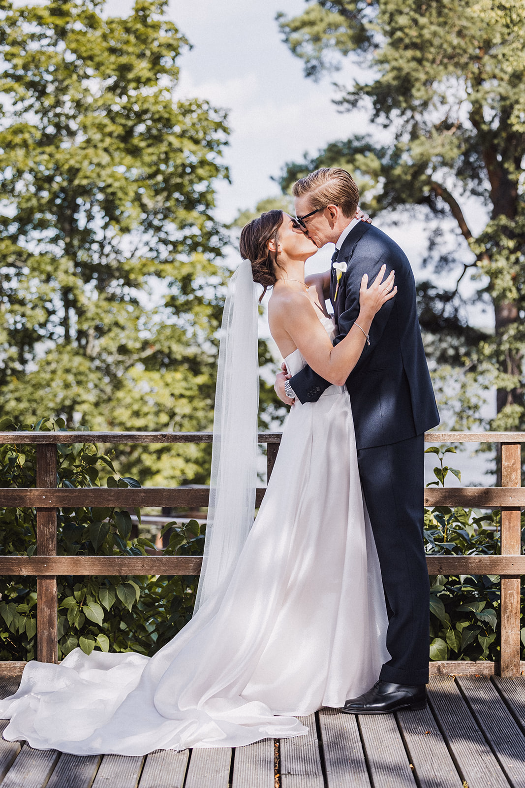 The newlyweds kissing at the end of their outdoor ceremony.