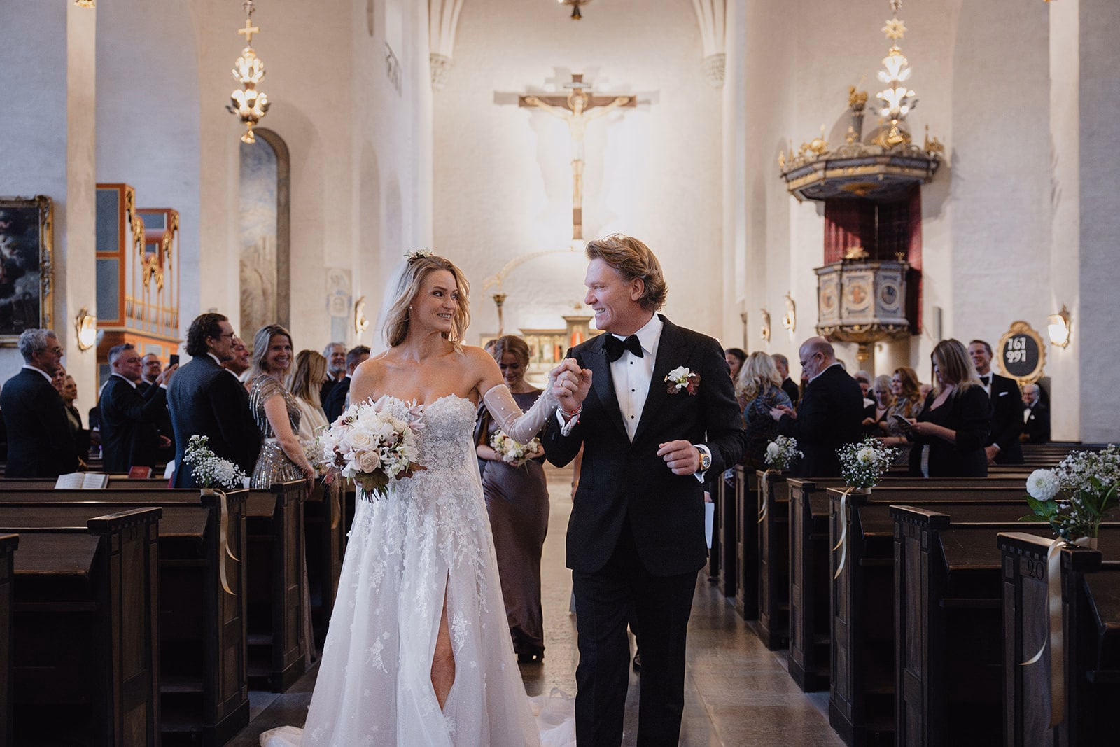 The newlyweds leaving the ceremony between applauding guests.
