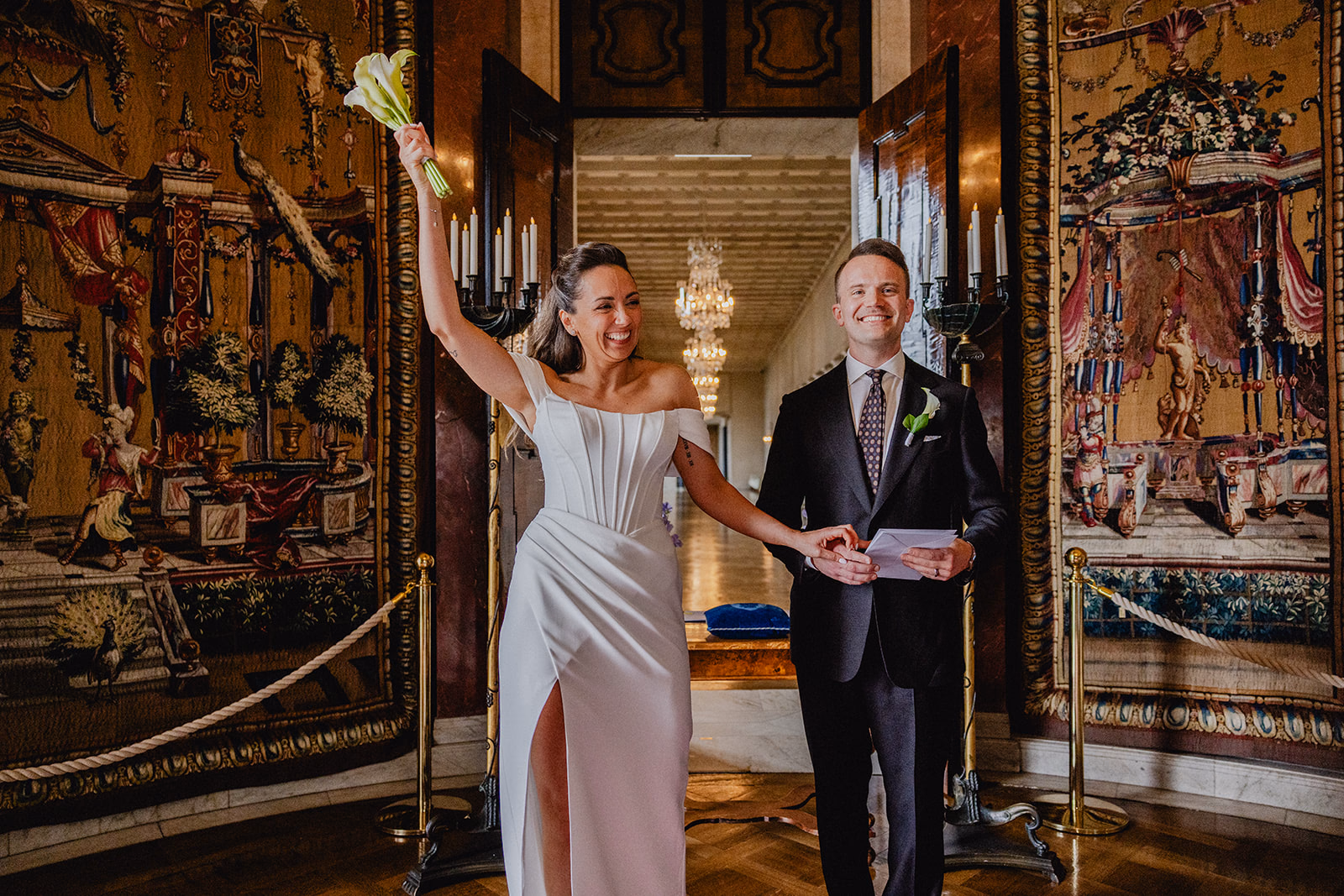 Gintare and Mikael raising their joined hands at the end of their Stockholm City Hall ceremony.