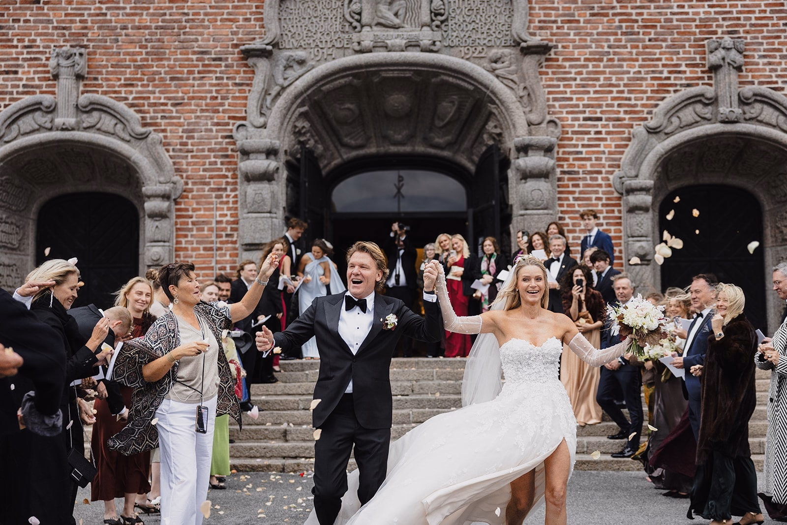 The newlyweds celebrating with guests outside Högalidskyrkan.