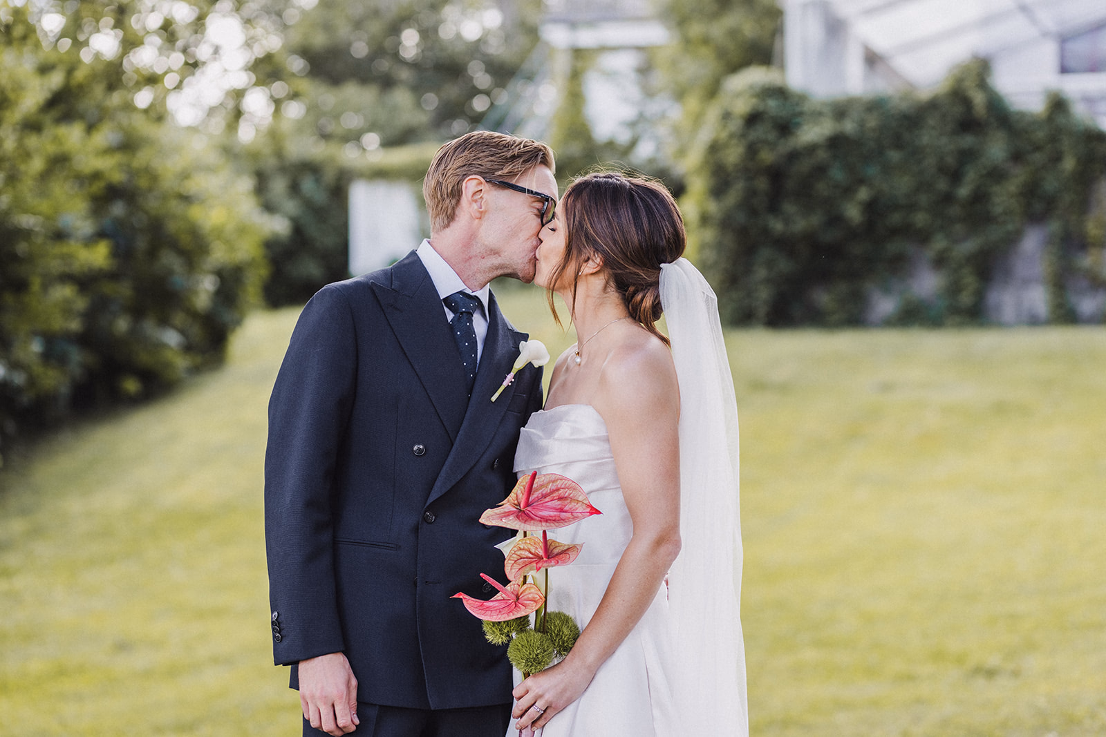 The newlyweds kissing in the manor garden.