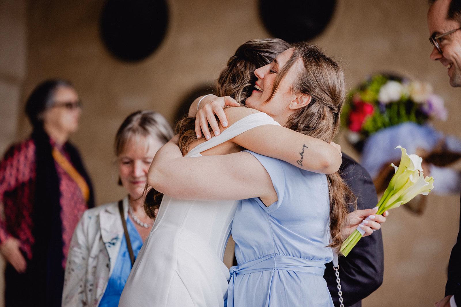 The bride embracing a guest after the Stockholm City Hall wedding ceremony.