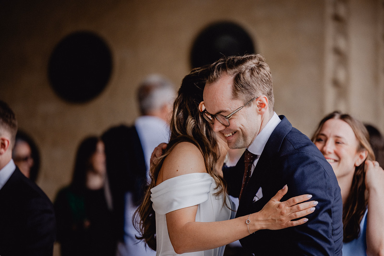 Gintare and Mikael laughing as they embrace a guest outside Stockholm City Hall.
