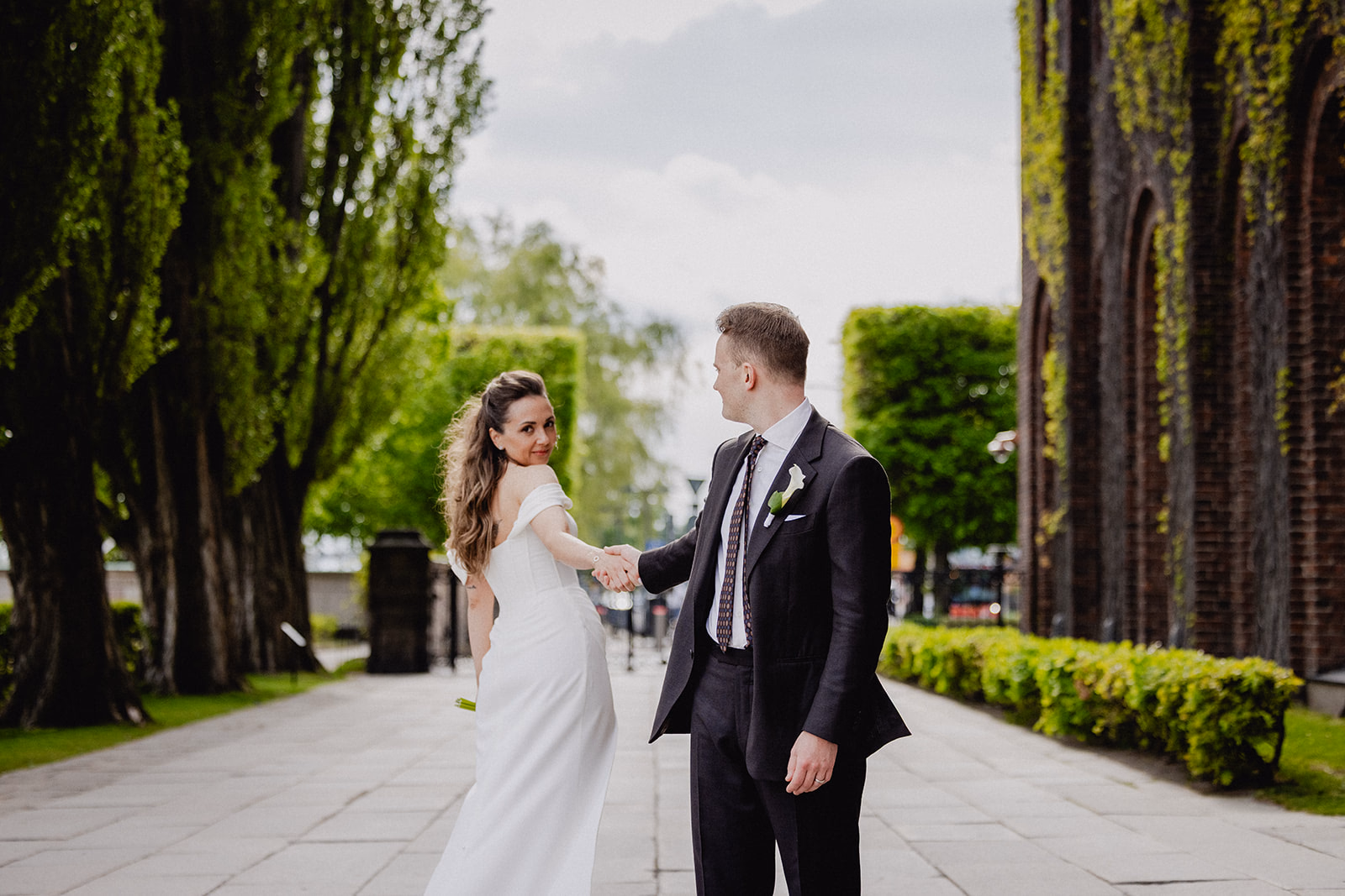 Gintare and Mikael walking through the garden beside Stockholm City Hall.