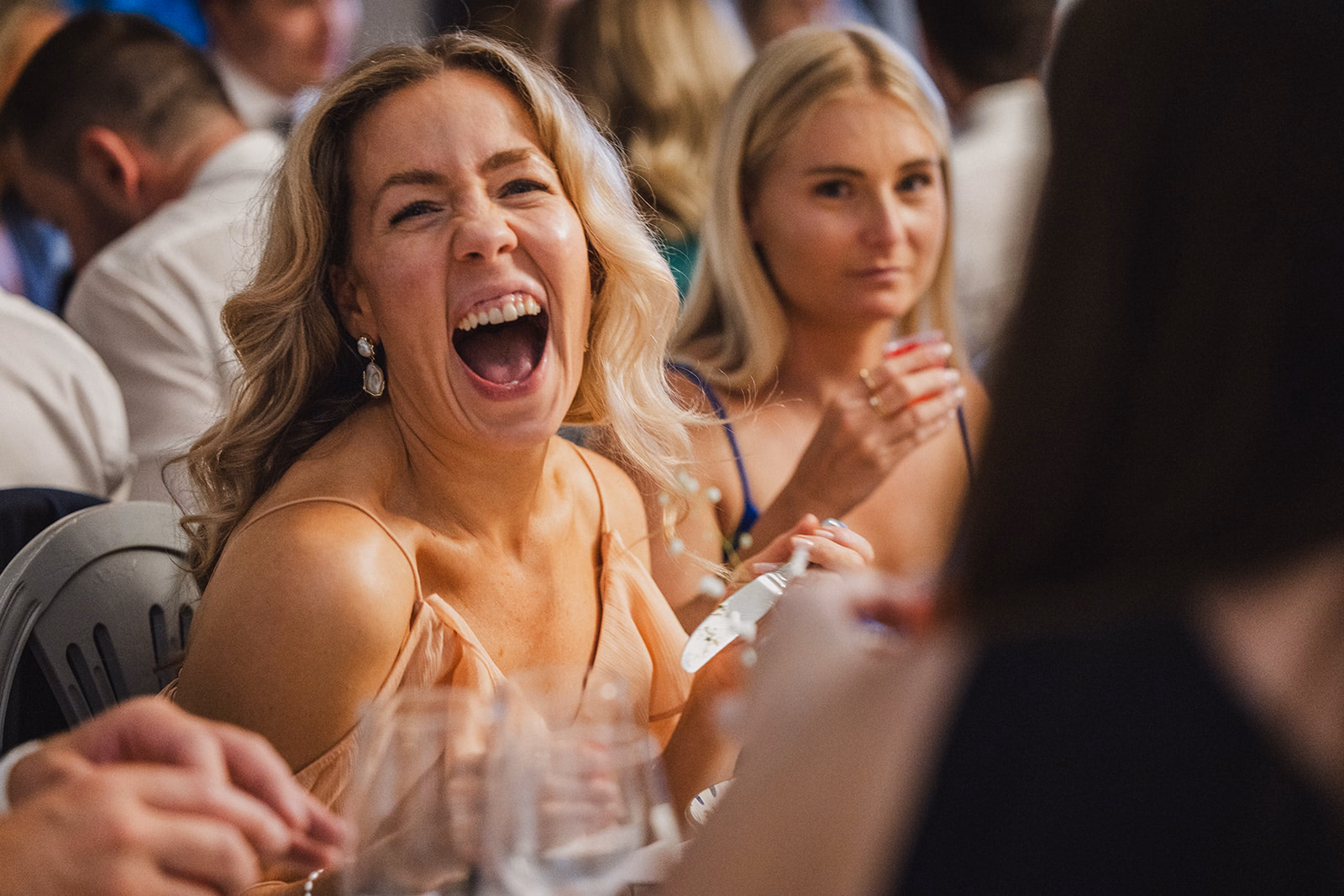 A wedding guest laughing during the dinner speeches.