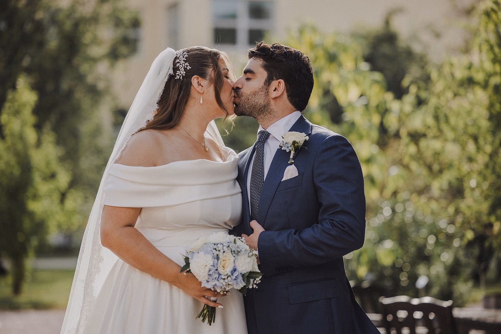 Sara and Kamran kissing during their garden portraits.