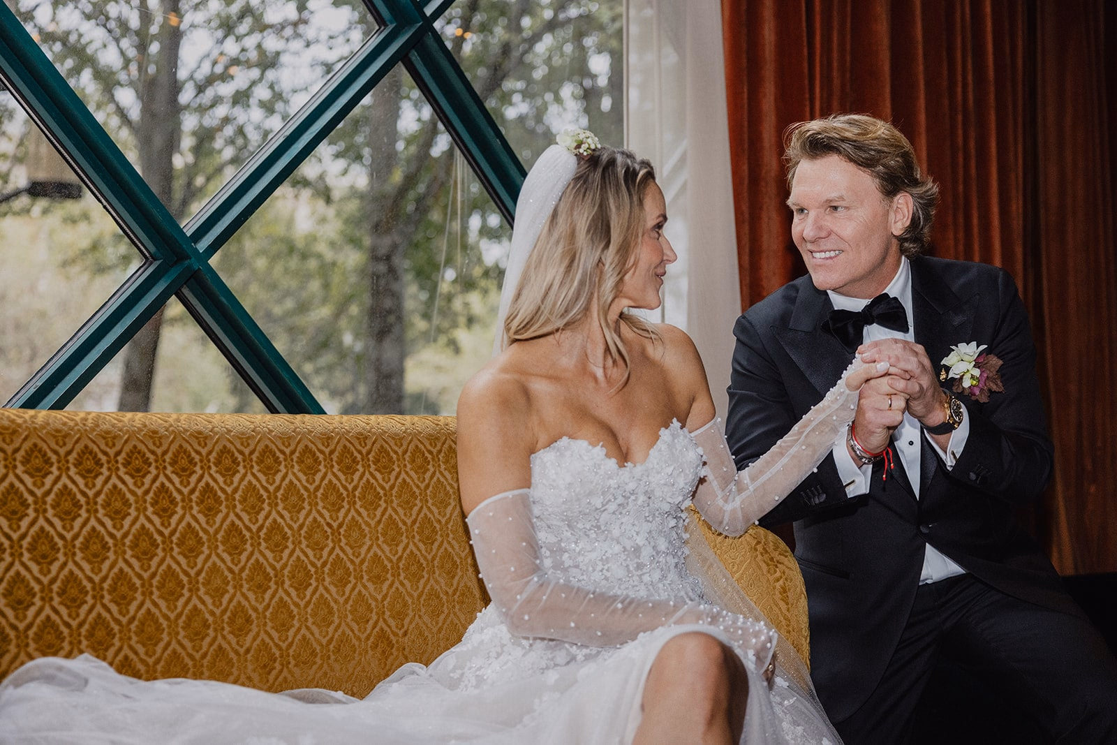 The newlyweds smiling together during a seated portrait.
