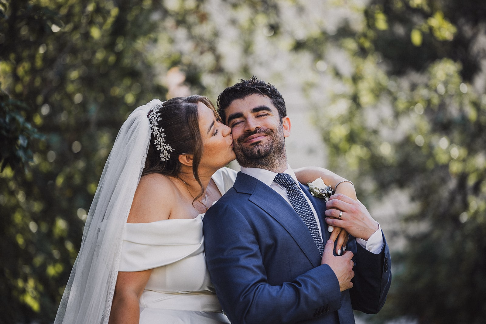 Sara and Kamran laughing together beneath the trees.