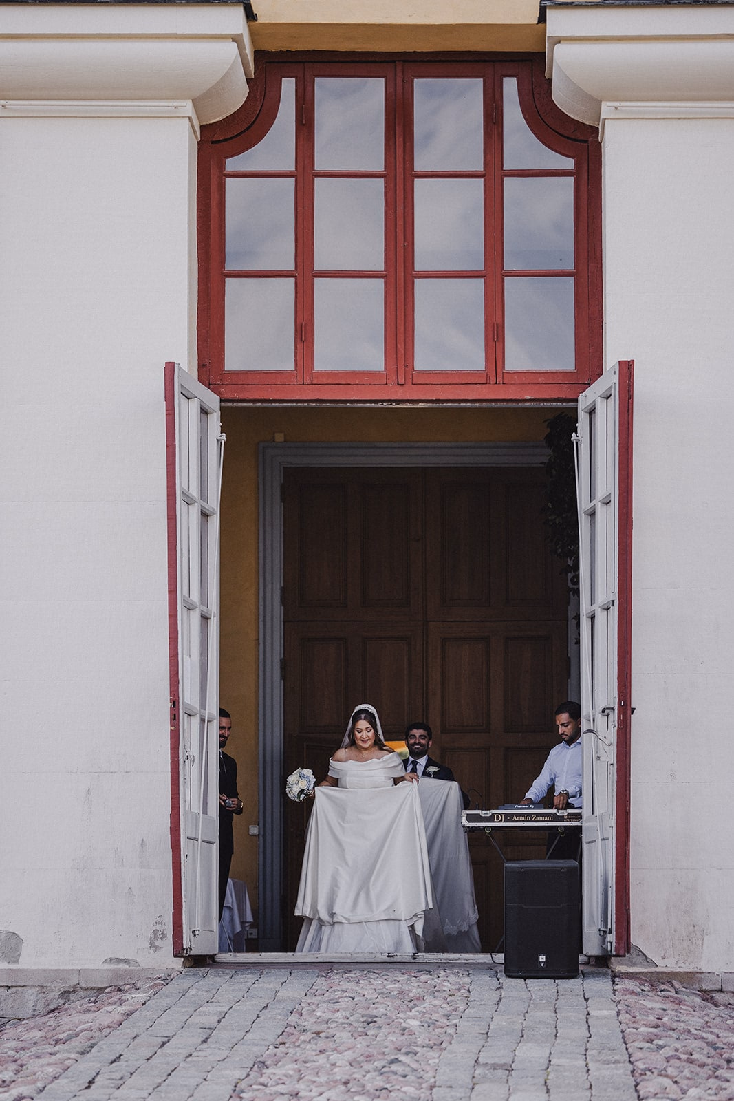 The newlyweds standing together in the reception doorway.