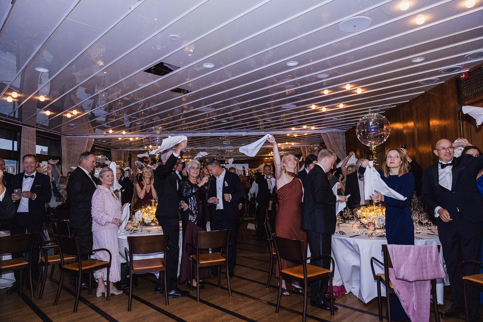Wedding guests welcoming the newlyweds into the dinner room.