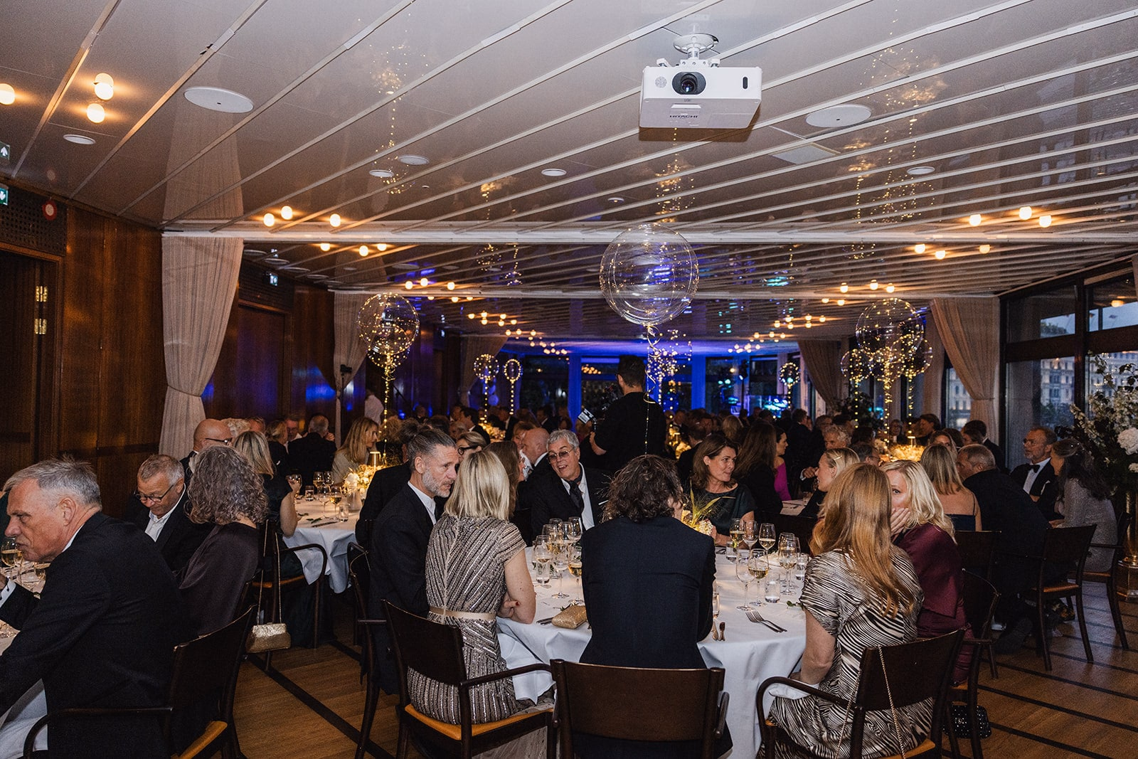 Wedding guests seated together for dinner at Café Opera.