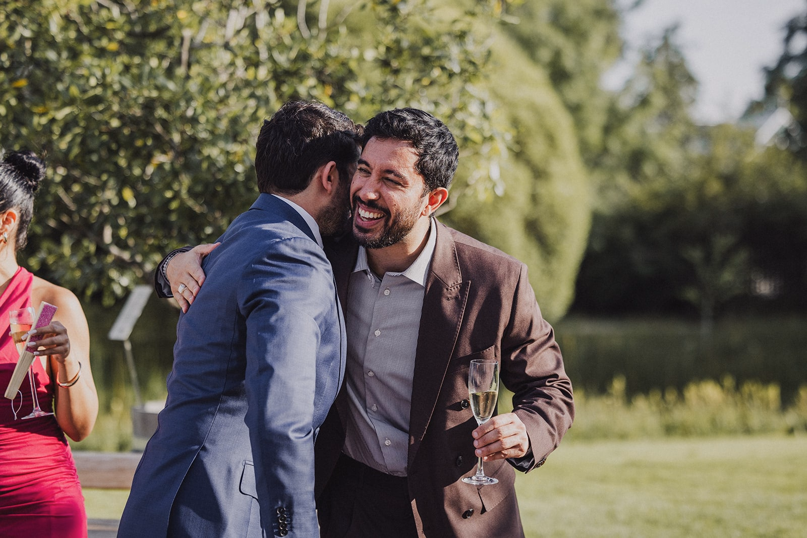 Two wedding guests embracing during the reception.