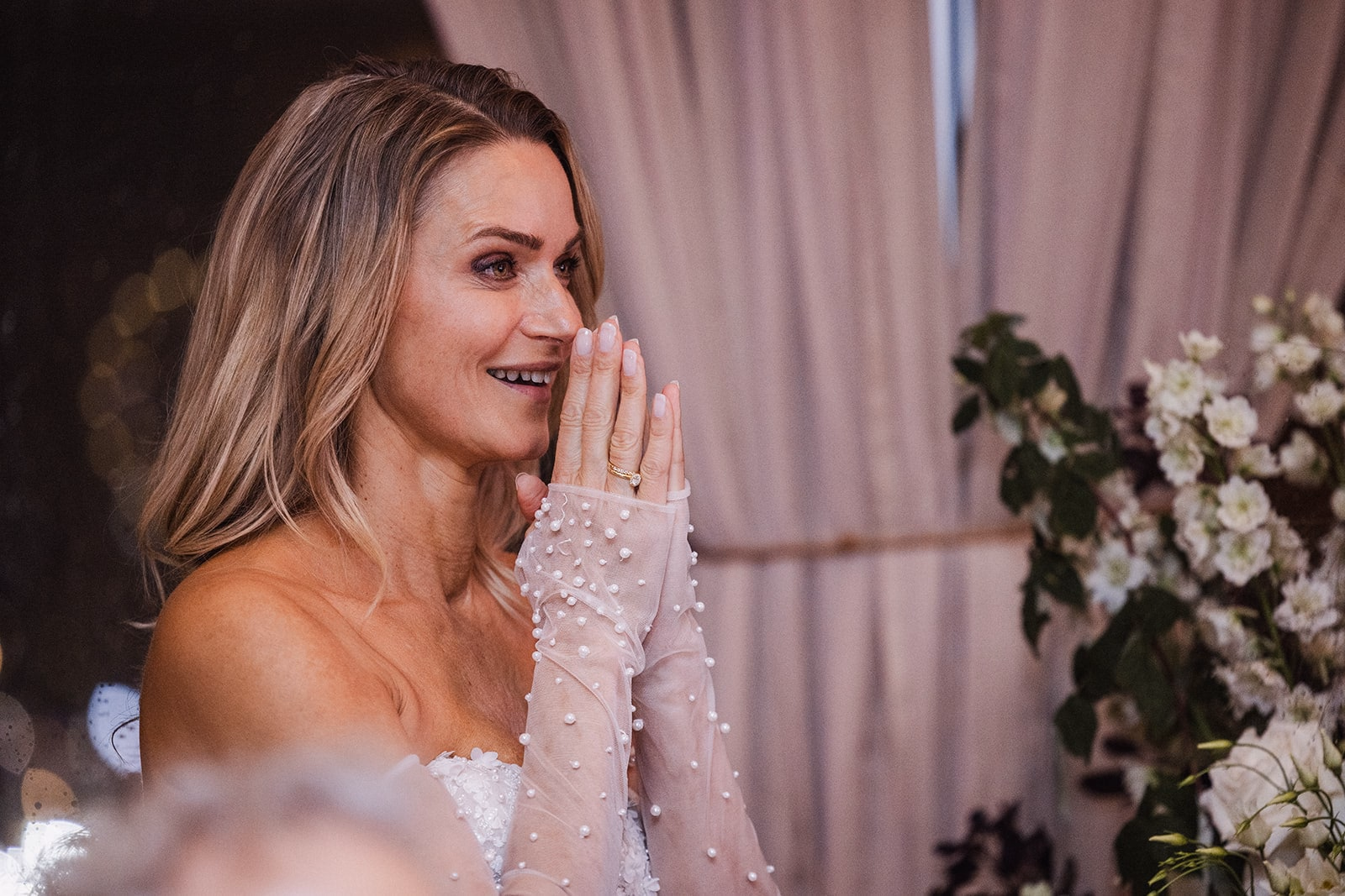 The bride reacting to a speech during the wedding dinner.