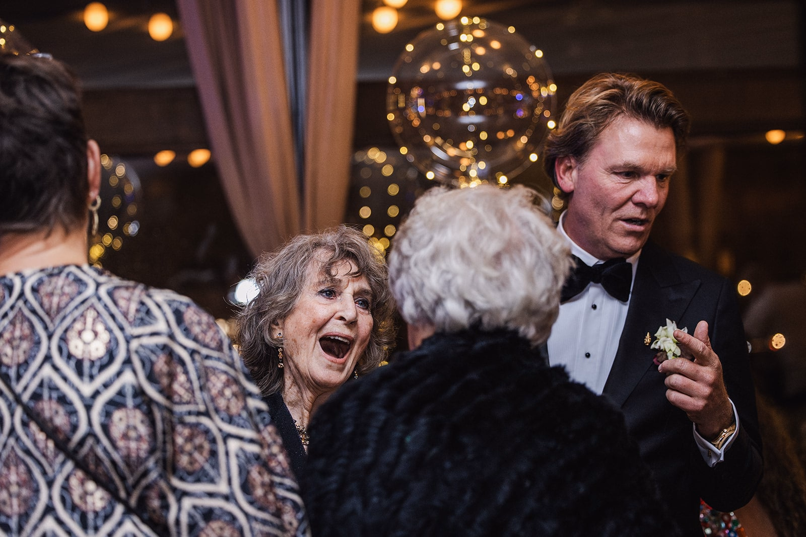 A wedding guest laughing during a dinner speech.