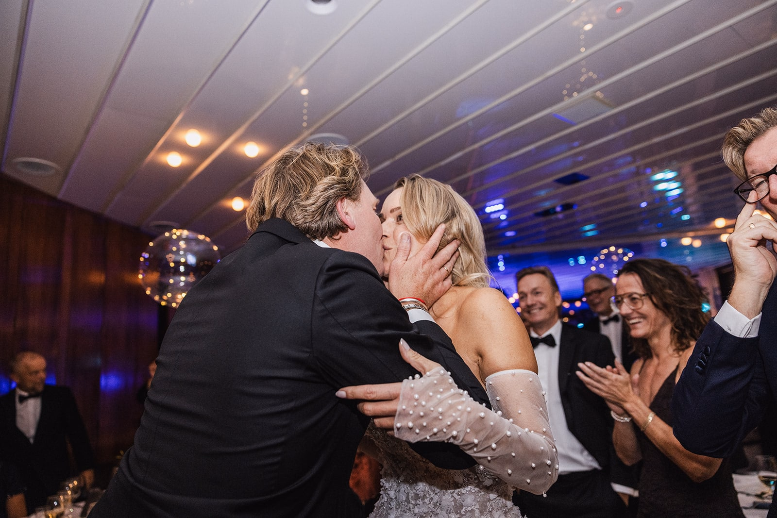 The newlyweds embracing a guest during the dinner celebration.