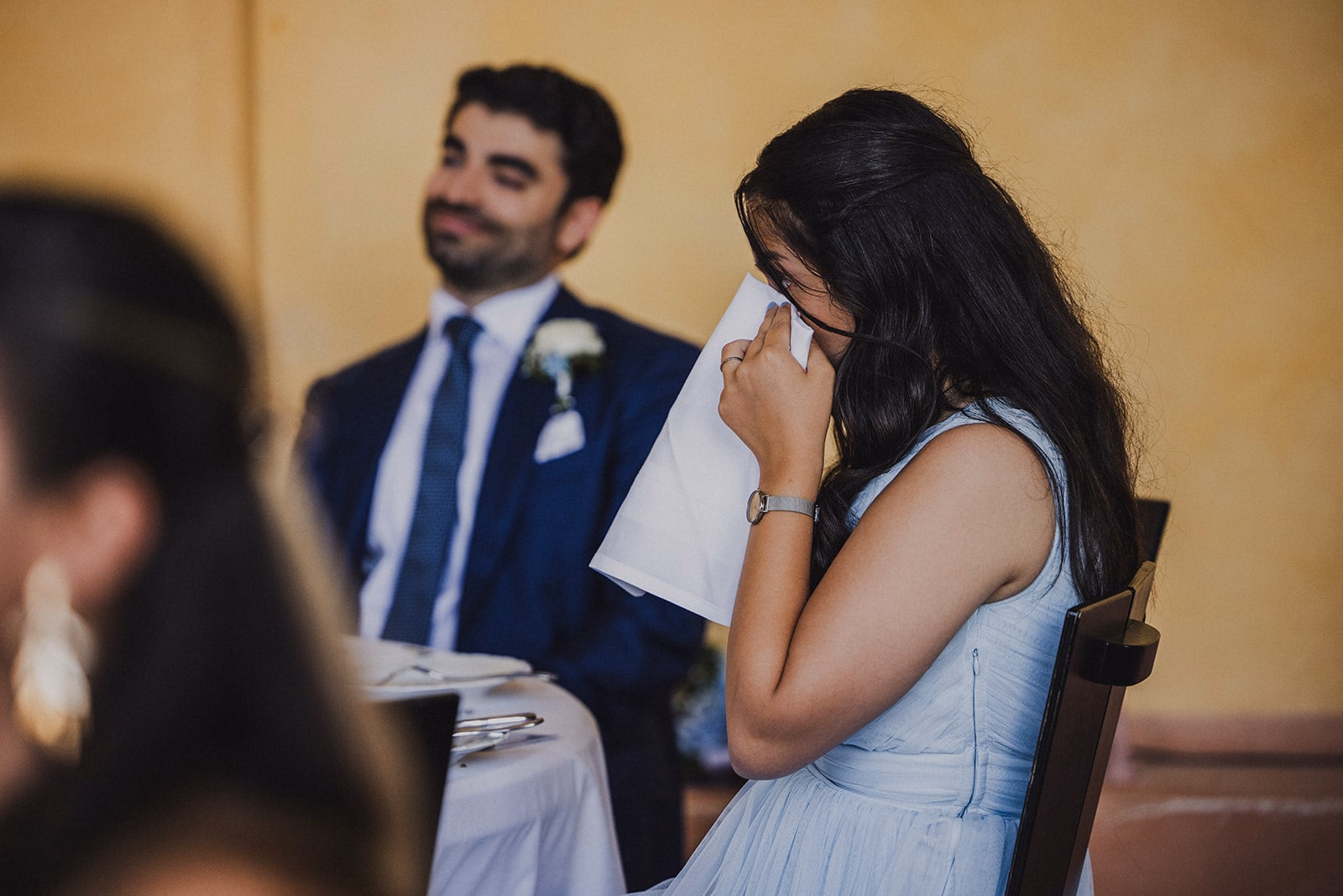 A wedding guest reacting emotionally to a dinner speech.