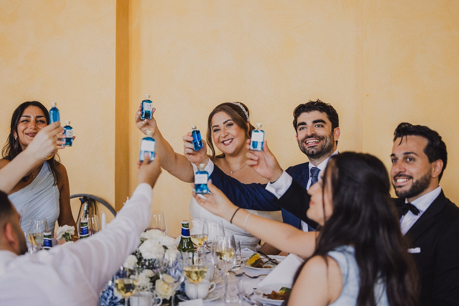 Wedding guests raising their glasses in a toast.