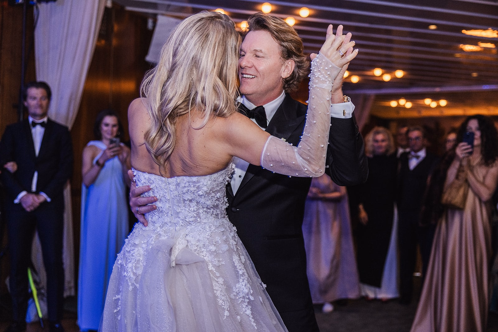 The newlyweds smiling together during their first dance.