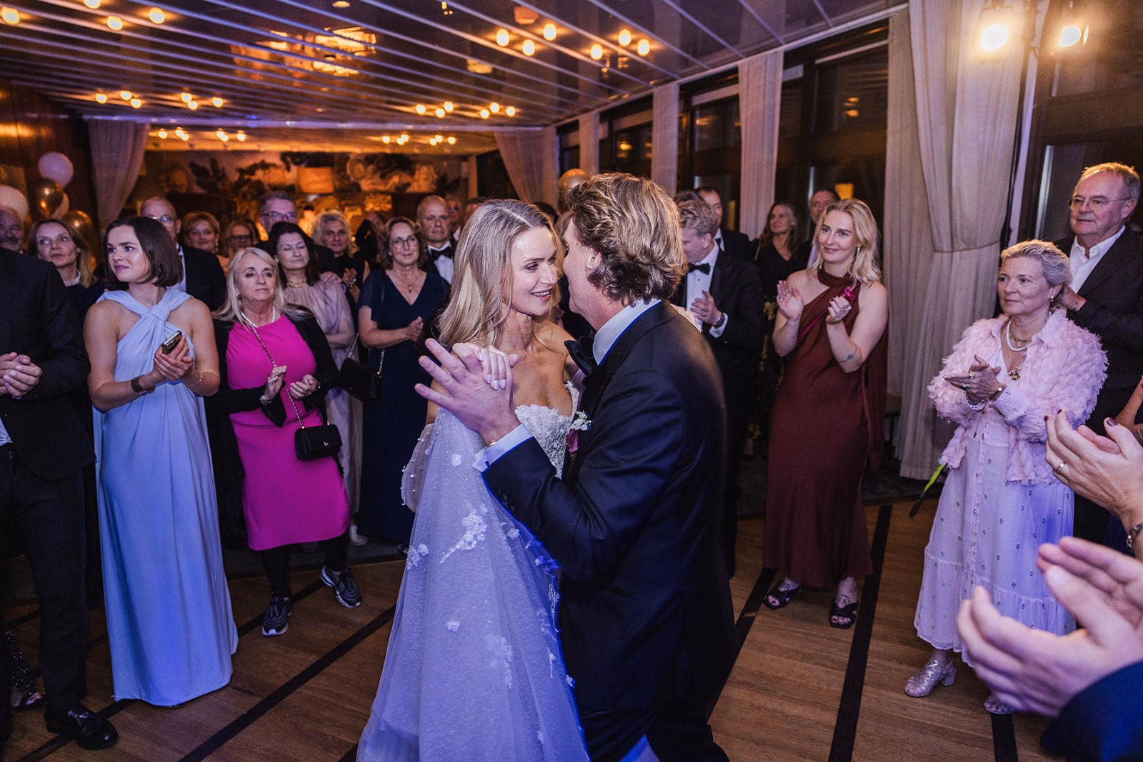 Wedding guests gathered around the dance floor for the first dance.