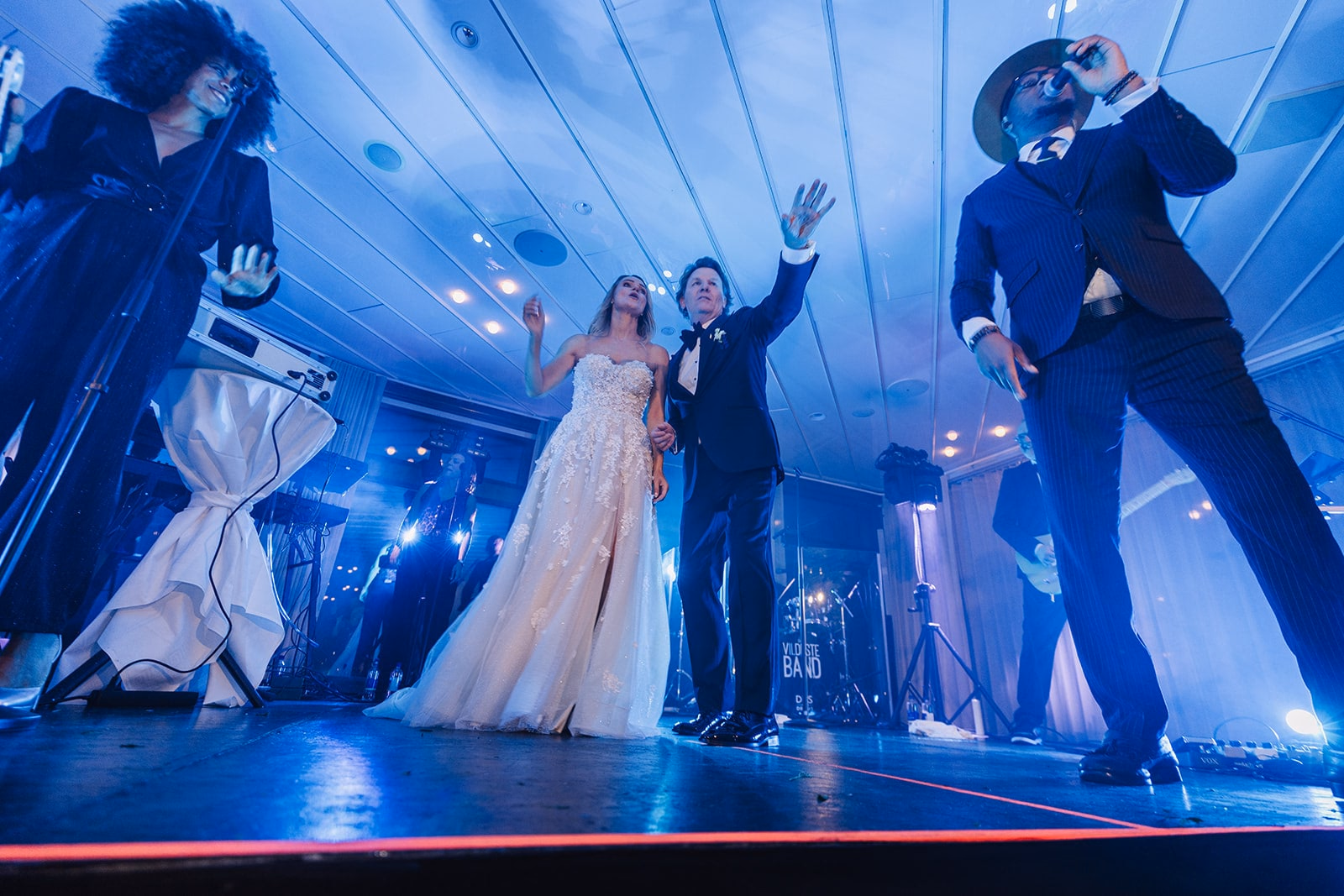 The newlyweds and musicians on stage during the wedding party.