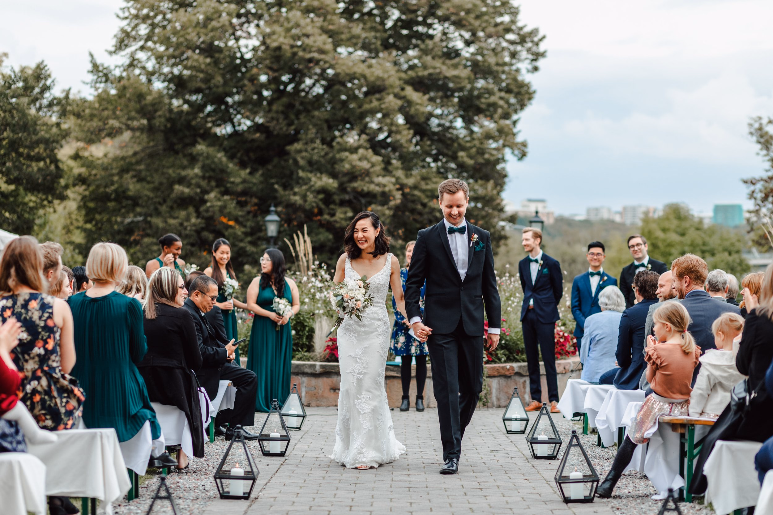 Gli sposi passano tra gli invitati dopo una cerimonia all’aperto.