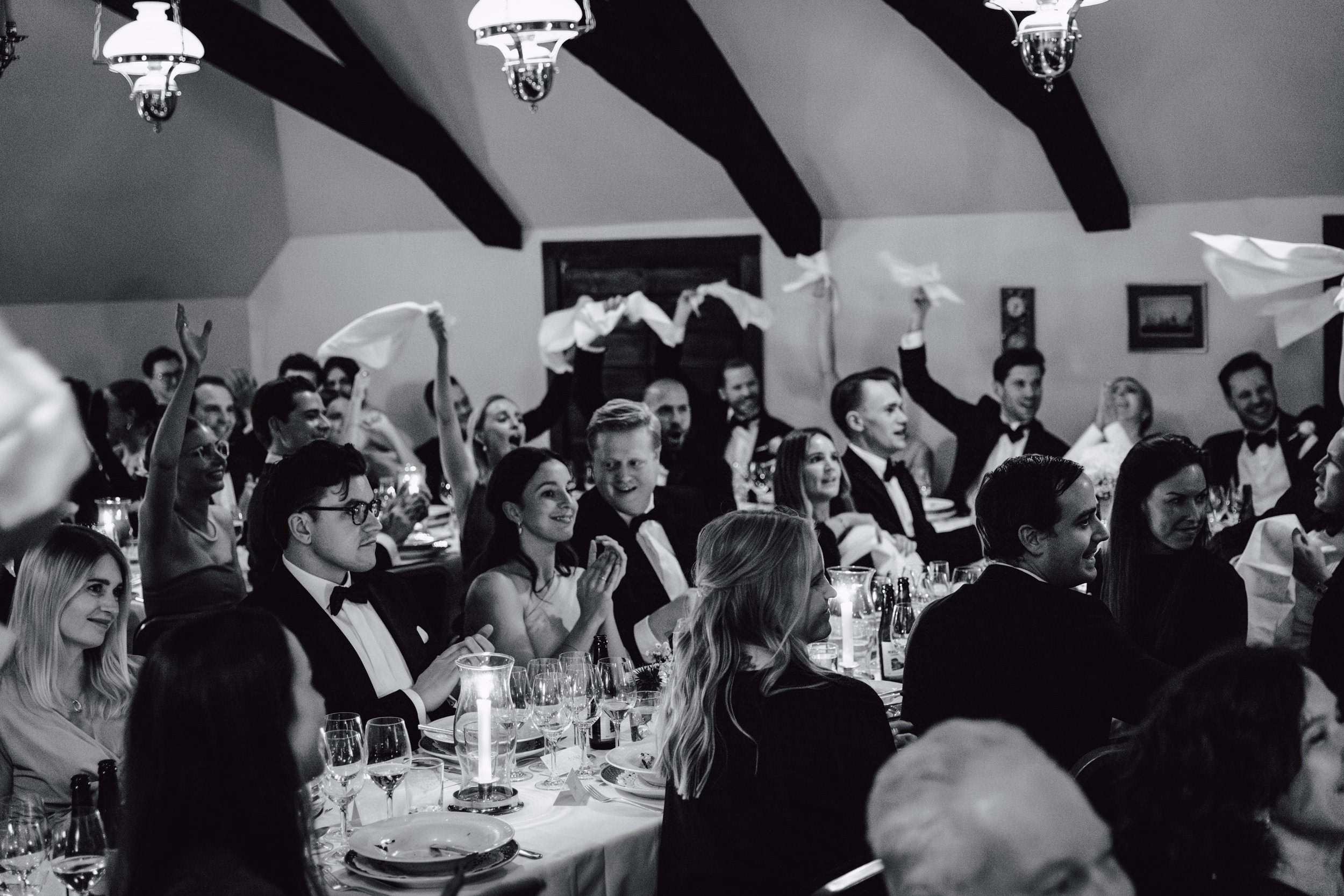 Gli invitati festeggiano insieme durante il ricevimento, in bianco e nero.