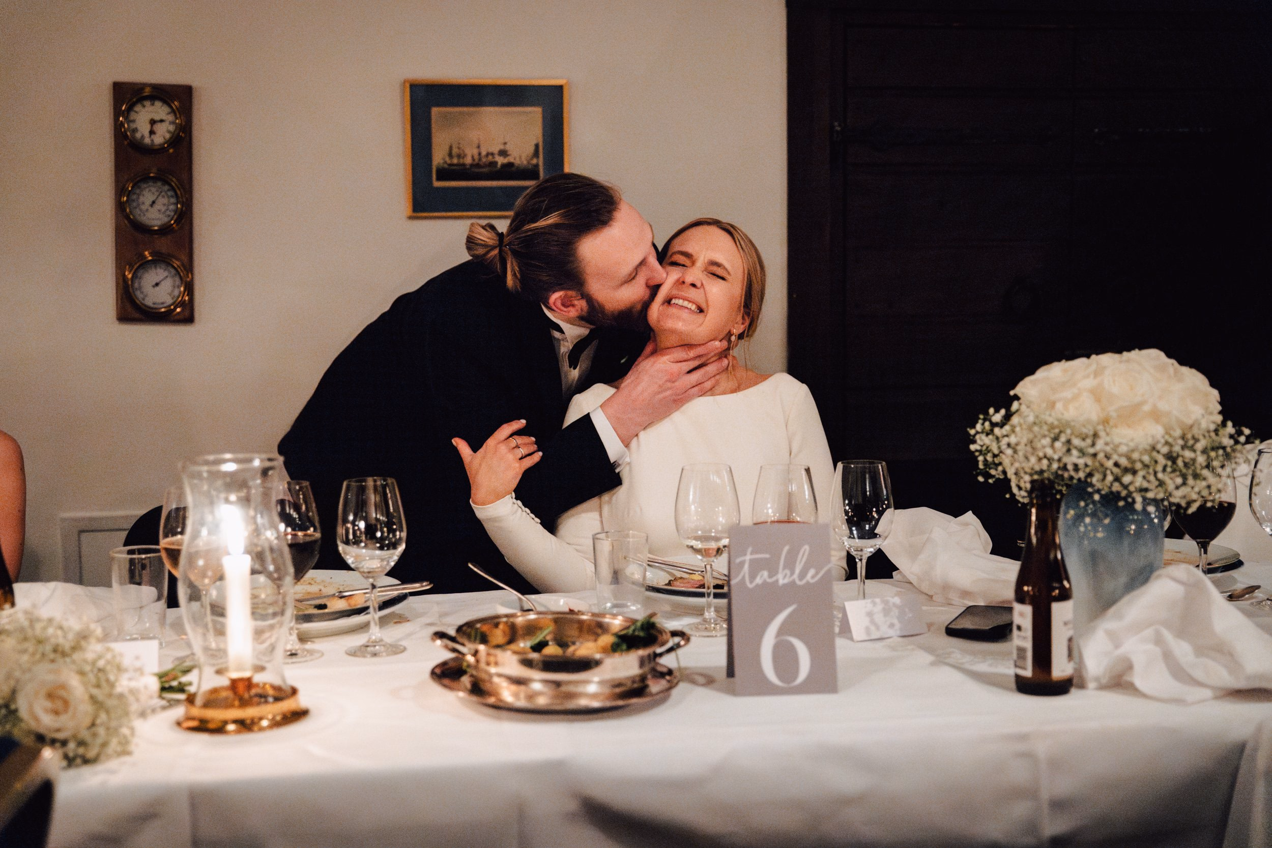 Lo sposo bacia la sposa durante la cena di matrimonio.