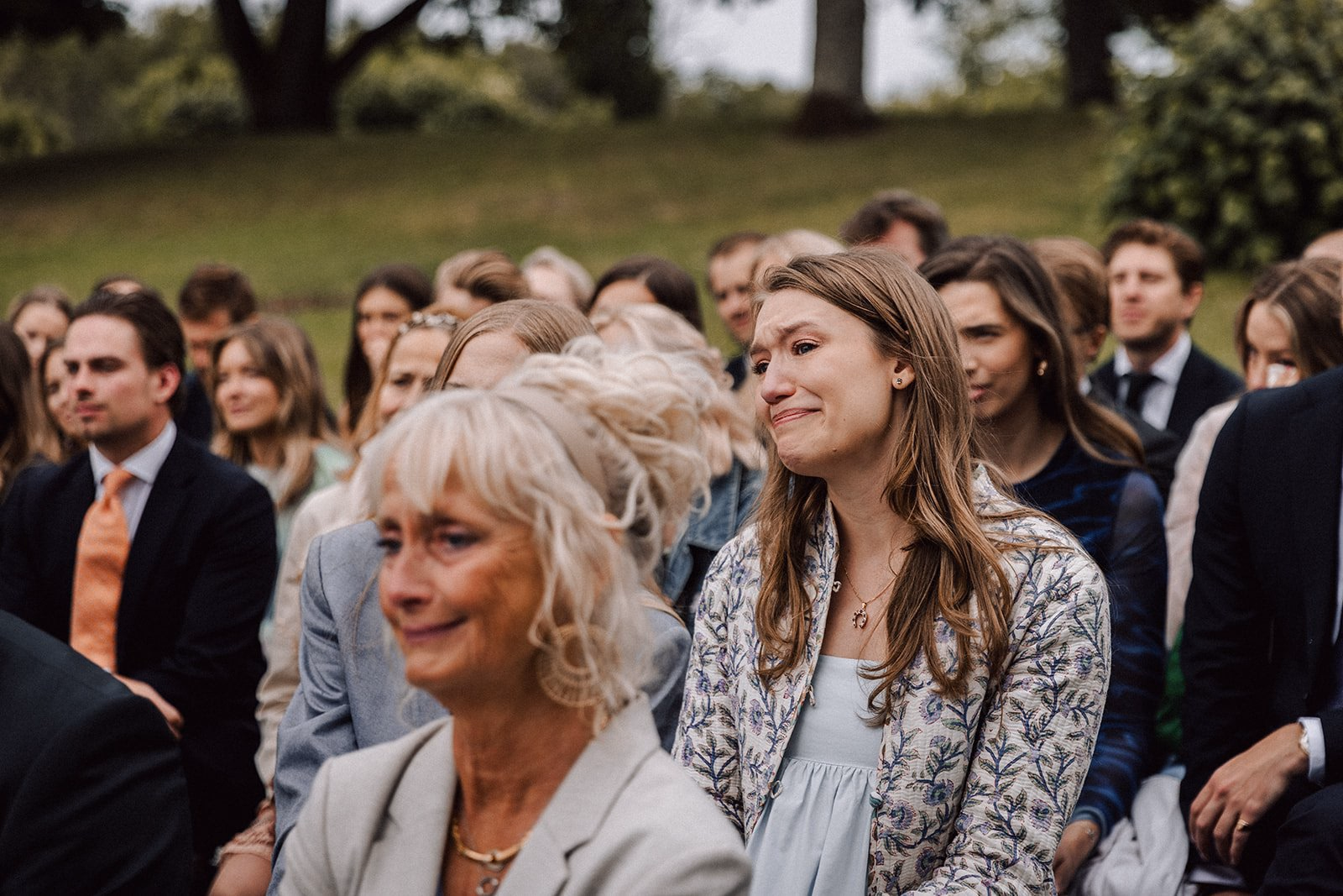 Gli invitati assistono a una cerimonia di matrimonio all’aperto.