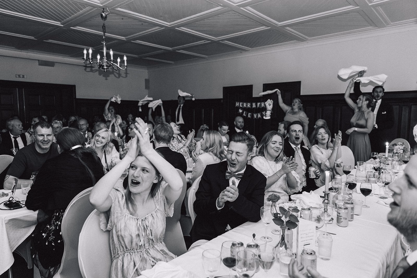 Gli invitati festeggiano sollevando i tovaglioli, in bianco e nero.