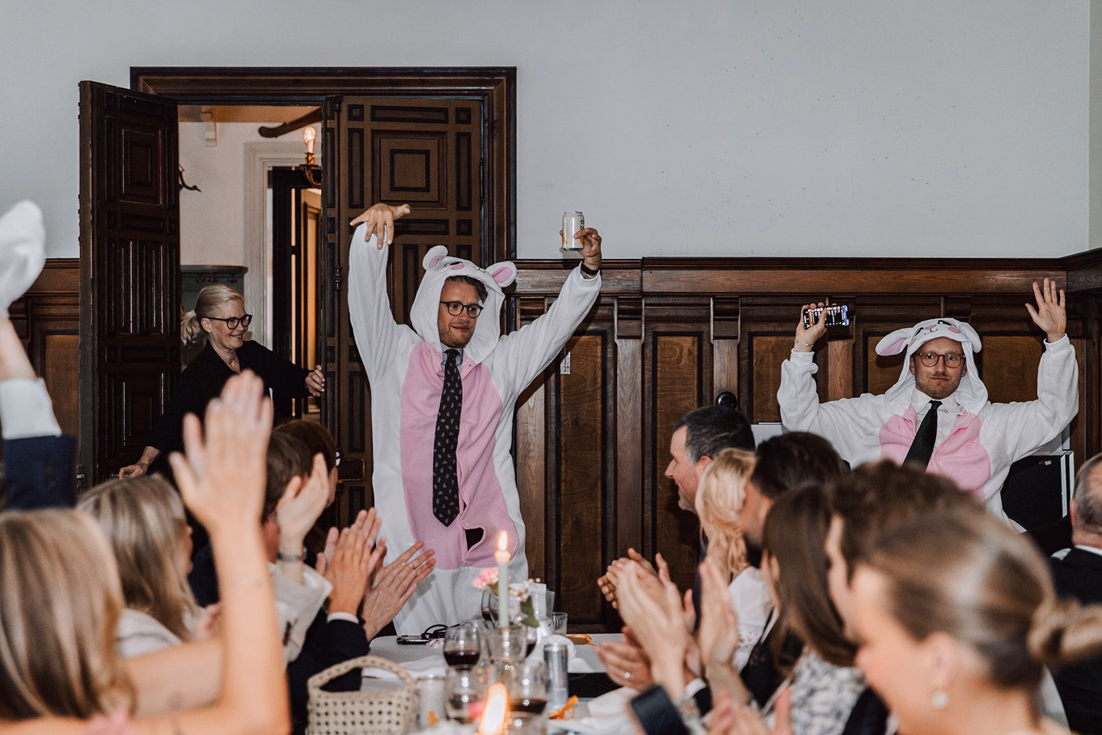 Gli invitati applaudono due persone con cappelli da chef durante la cena.