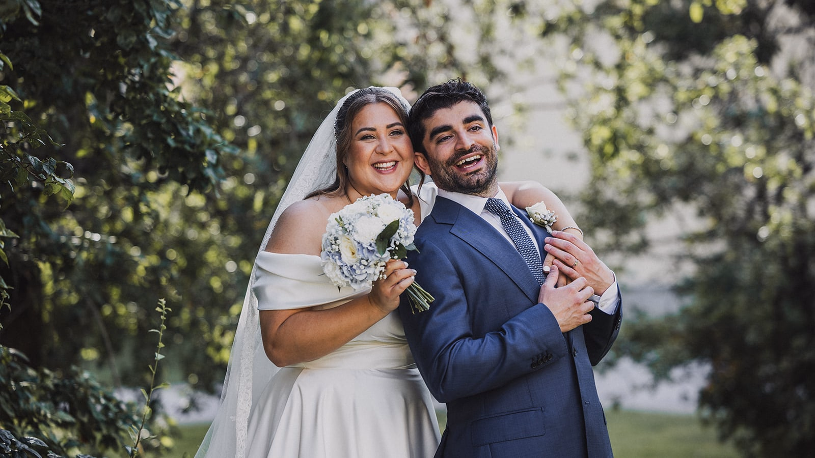 Sara and Kamran laughing together during their wedding portraits in the Botanical Garden in Uppsala.