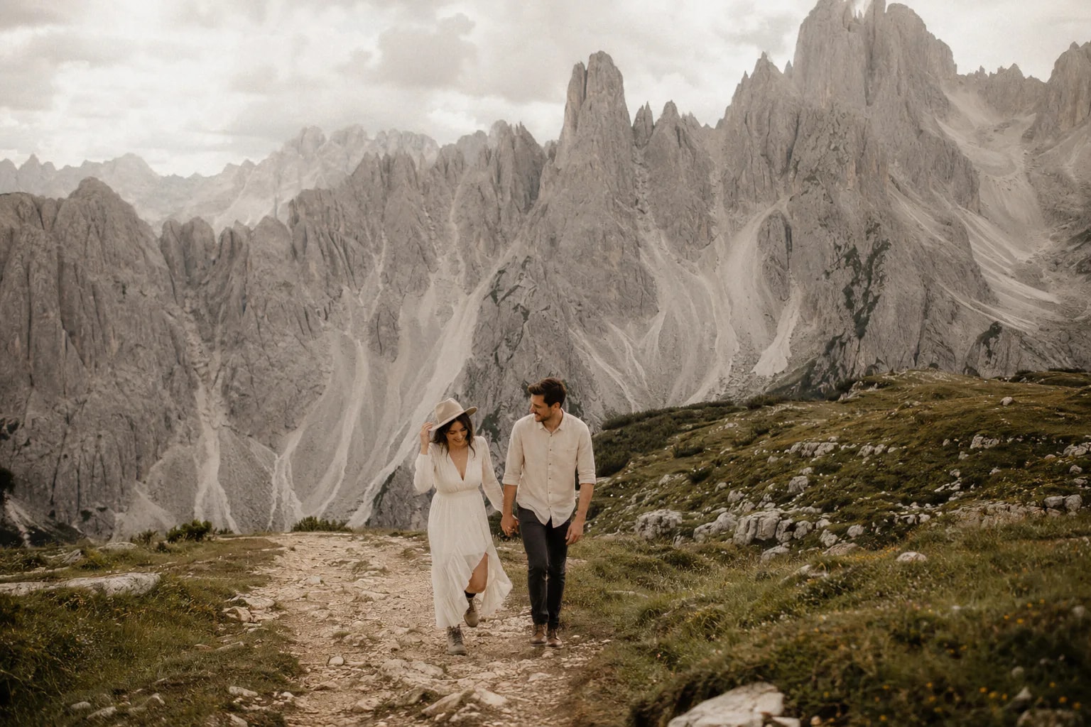 A couple hiking beneath the Cadini di Misurina peaks during a Dolomites wedding photography session.