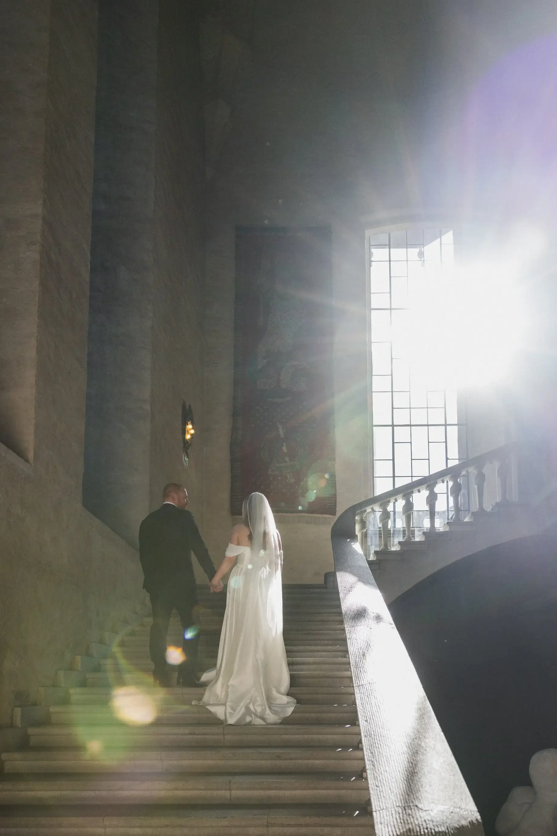 Bride standing in a beam of light at Stockholm City Hall.