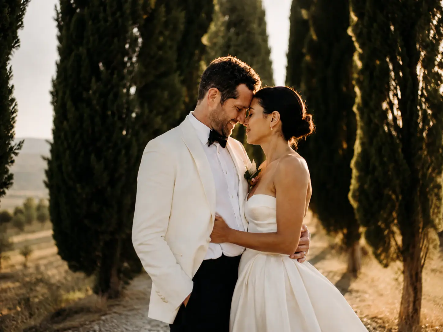 wedding couple portrait in tuscany, italy taken during sunset with cypress trees.