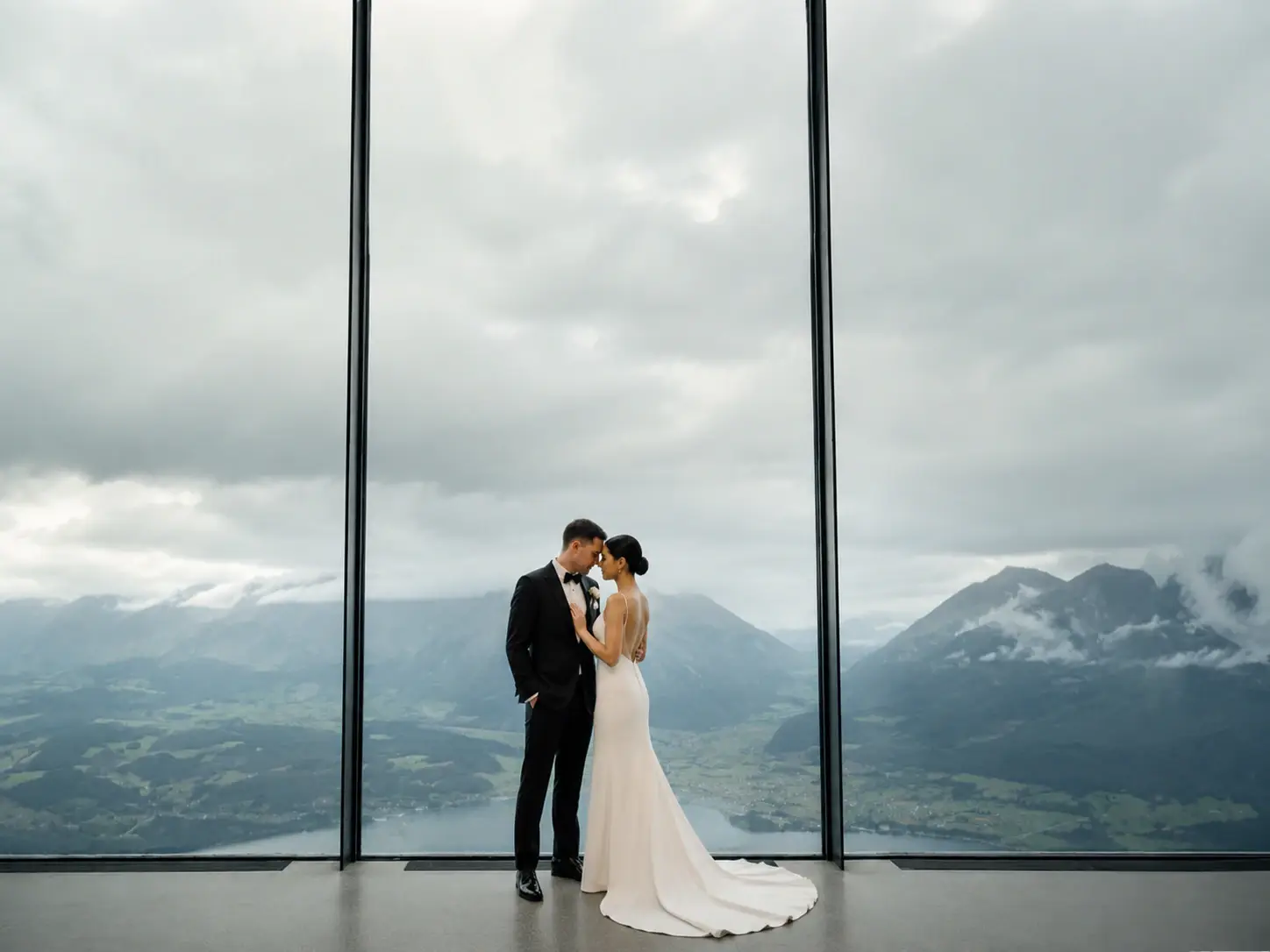 Intimate wedding couple at LUMEN Museum in the Dolomites with panoramic mountain views through floor-to-ceiling windows.