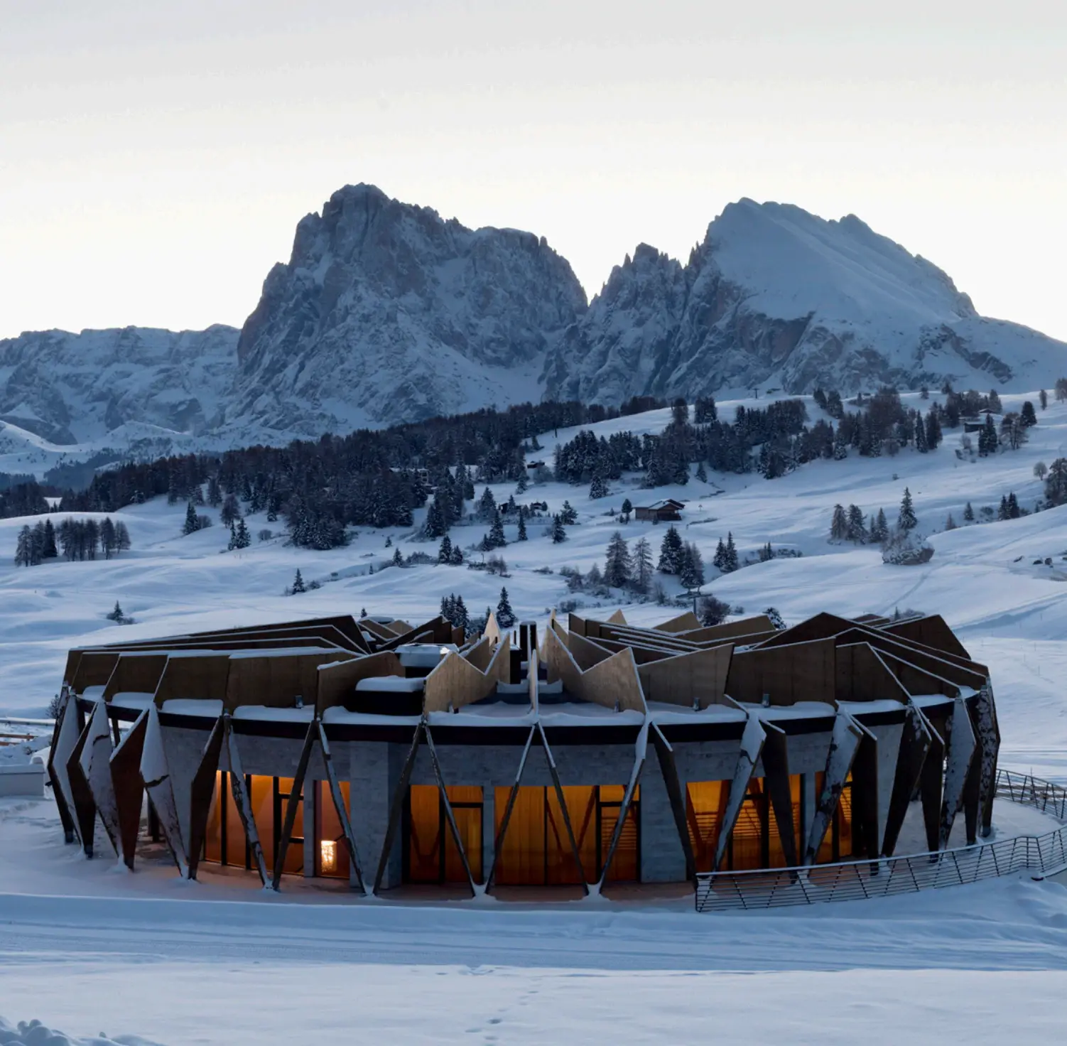 Circular mountain venue surrounded by snow-covered peaks.
