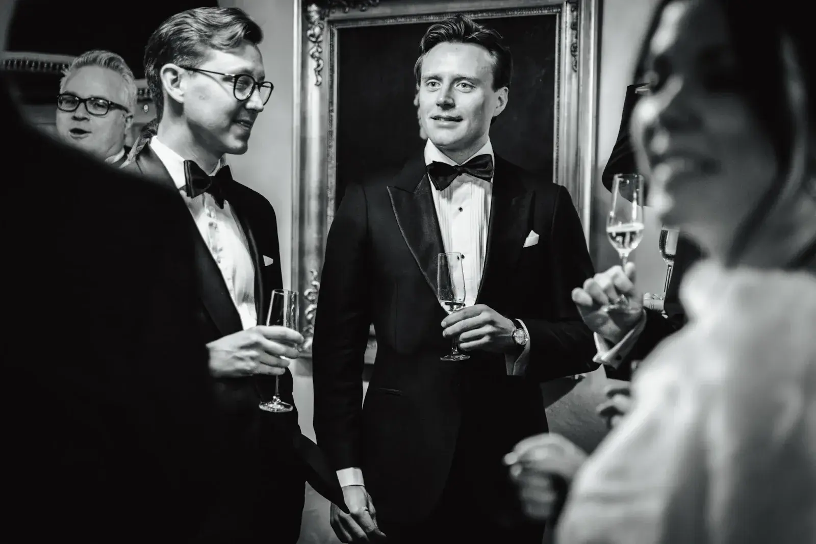 Wedding guests talking during a reception in central Stockholm, photographed in black and white.